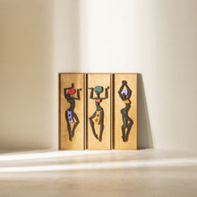 Load image into Gallery viewer, A set of three wooden wall hangings depicting African dancers, with each figure in different pose, mounted on a wall.