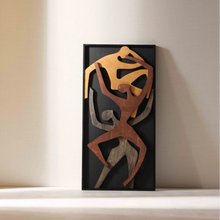 Load image into Gallery viewer, A vertical wooden wall decor featuring an abstract design with multiple human figures in shades of brown and gray